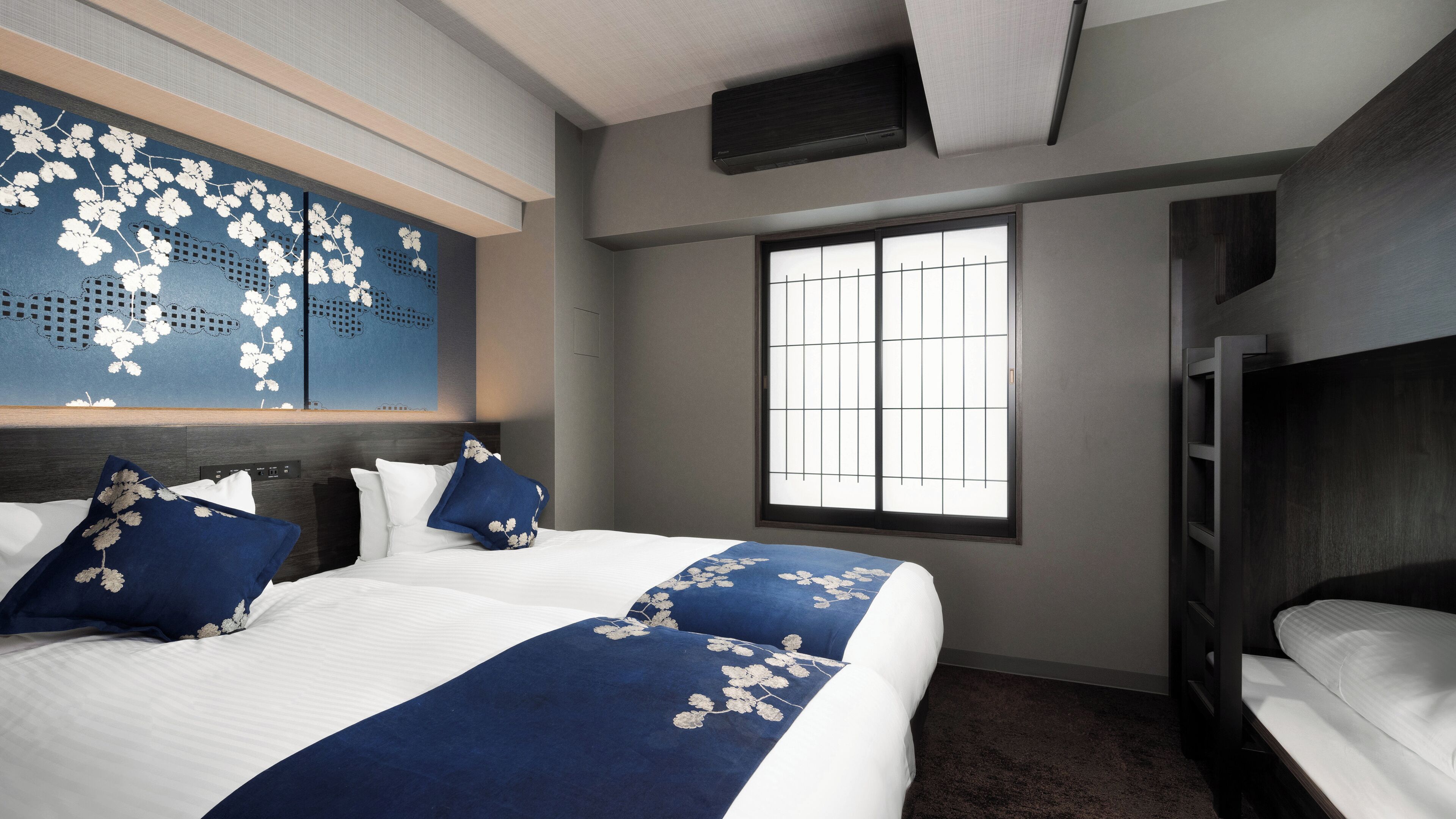 Hotelkamer met een groot bed, een raam met tralies, een flatscreen televisie en een donker houten hoofdeinde.