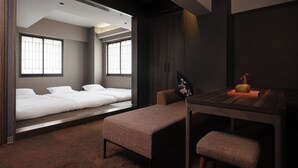 Ein modernes Hotelzimmer mit einem großen Bett, einem kleinen Tisch mit einer Vase und einer Bank.