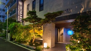 Das äußere Erscheinungsbild des #MIMARU APARTMENT HOTEL mit gut beleuchtetem Eingang, modernem Design und einer Schilderung des Hotelnamens.