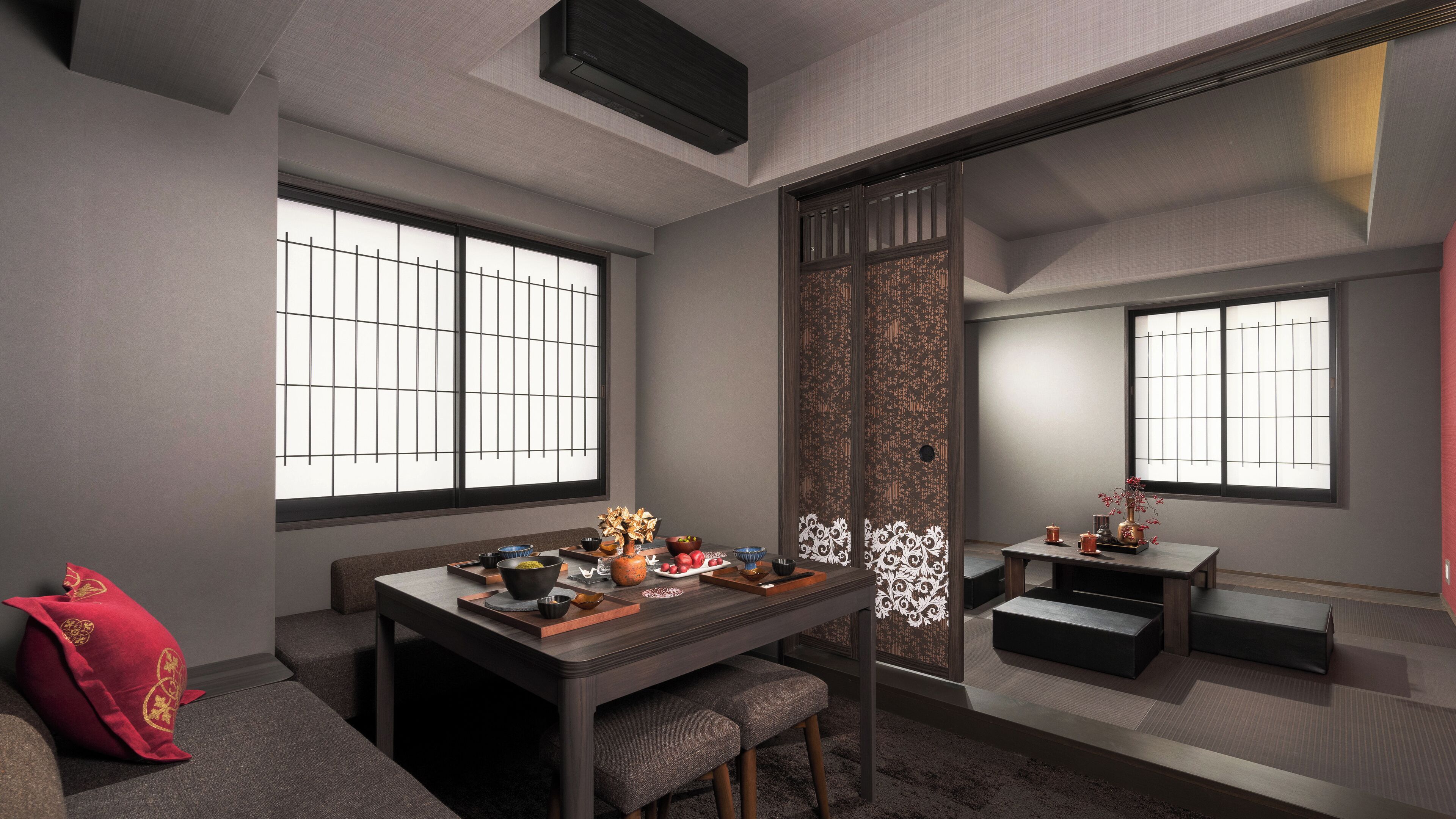 A traditional Japanese-style room with tatami flooring, a low table with a tea set, and sliding doors.