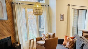 A cozy living room with a fireplace, a sofa, a chair, and a coffee table. - Newly Updated Cozy Condo in the Heart of Wintergreen!  Pet friendly. (Wintergreen)