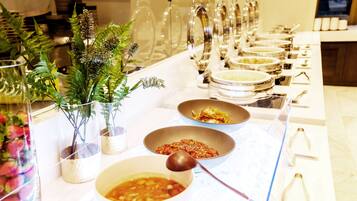 A buffet setup with various dishes and utensils.