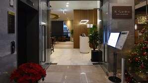 A modern lobby with a reception desk, a Christmas tree, and a sign for 'H Garden Buffet & Pub Restaurant'. - Hotel Intrada Icheon (Icheon)