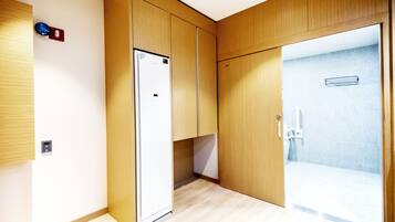 A modern bathroom with wooden cabinetry, a shower area, and a visible toilet.