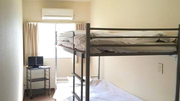 Habitación con literas, escritorio y aire acondicionado.