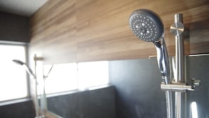 Una ducha moderna con cabezal de ducha de mano y llave de pared.