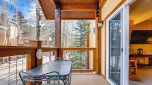 A wooden deck with a table and chairs, a sliding glass door, and a view of trees and buildings. - Breckenridge Condo w/ Spa Access: Walk to Ski Lift (Breckenridge)