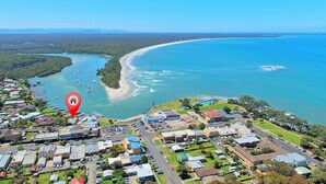 Vue aérienne d’une ville côtière avec un port de plaisance, des immeubles résidentiels et une grande plage.