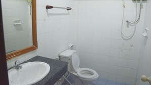 Un baño con lavamanos, inodoro y ducha.