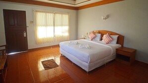 Una habitación de hotel con una cama grande, cabecero de madera y una mesita de noche.