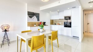 A modern kitchen with white cabinets, a built-in oven, and a microwave. - Mileni I by Interhome (Roses)
