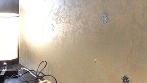 A power strip on a wall with a decorative panel. - Dongqu Light Inn (Taipei)