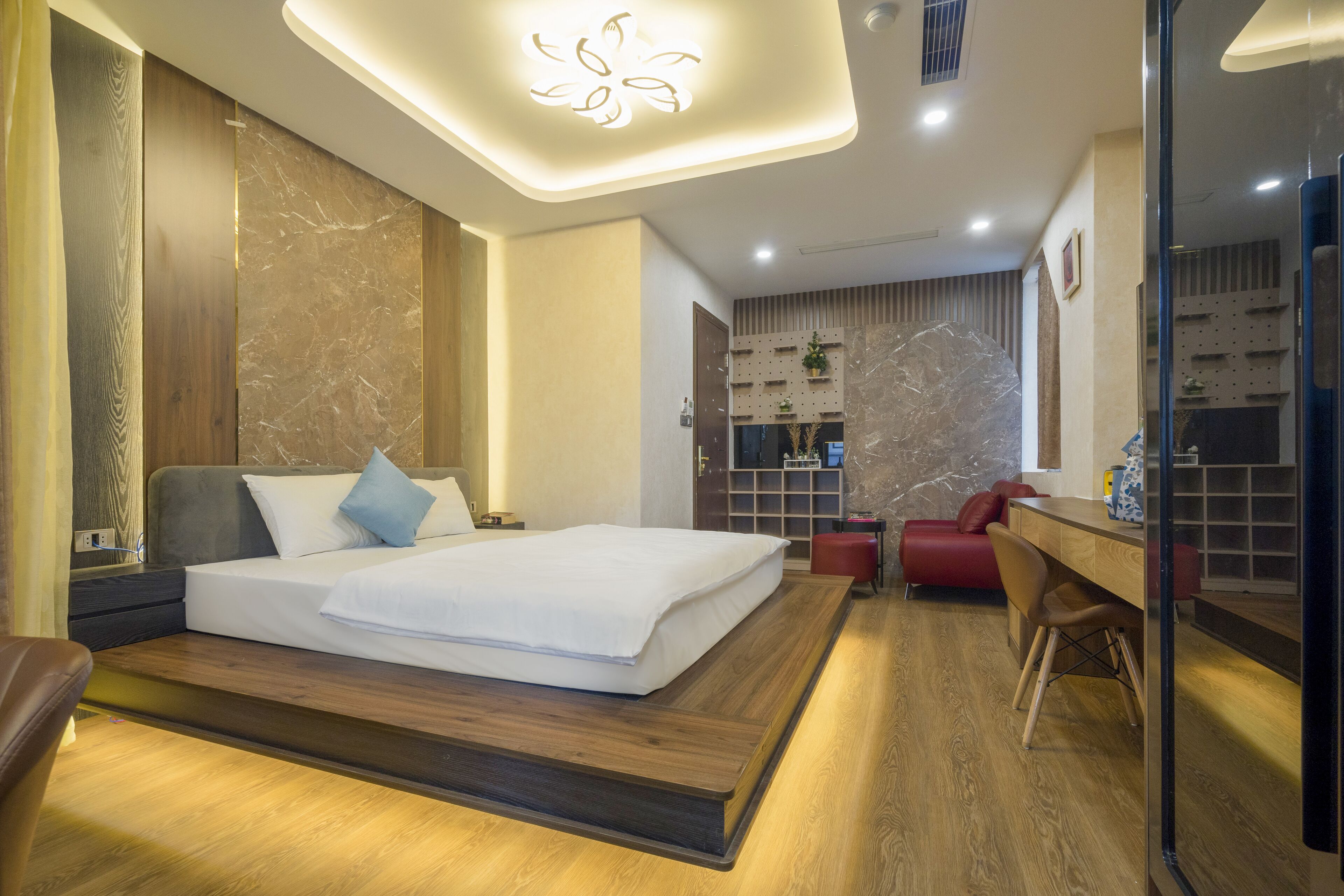 Una habitación de hotel moderna con una cama grande, un escritorio y una zona de estar.