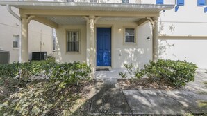 A two-story building with a blue door, a covered porch, and a small window. - Bridgewater_at_town_center_233 (Davenport)