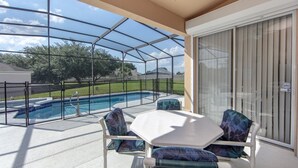 A covered patio with a pool, outdoor seating, and a view of the surrounding area. - Windsor_palms_8144 (Kissimmee)