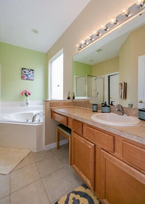 A bathroom with two sinks, a large mirror, and a vanity with cabinets.