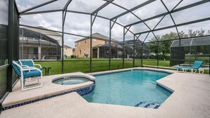 A covered outdoor swimming pool with lounge chairs and a hot tub. - Emerald_island_2703 (Kissimmee)