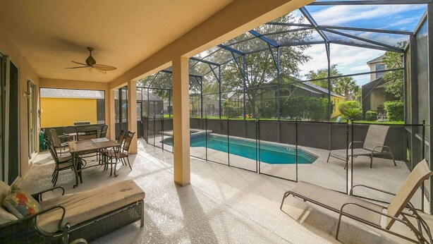 A covered patio with a pool, outdoor furniture, and a view of the neighborhood. - Emerald_island_8520 (Kissimmee)