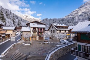 A snow-covered village with traditional buildings, a central square, and a mountain backdrop. - Le Bellevue 08 Cozy Alpine Apartment | Pool & Mountain Views, Argentière (Chamonix), France (Argentière (Chamonix))