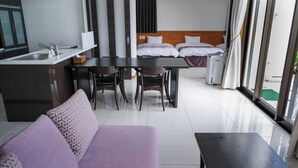 Una habitación de hotel moderna con comedor, sofá y cama.