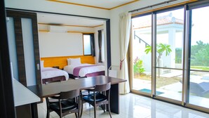Habitación de hotel con cama, escritorio y sillas. Amplia ventana con vistas al exterior.