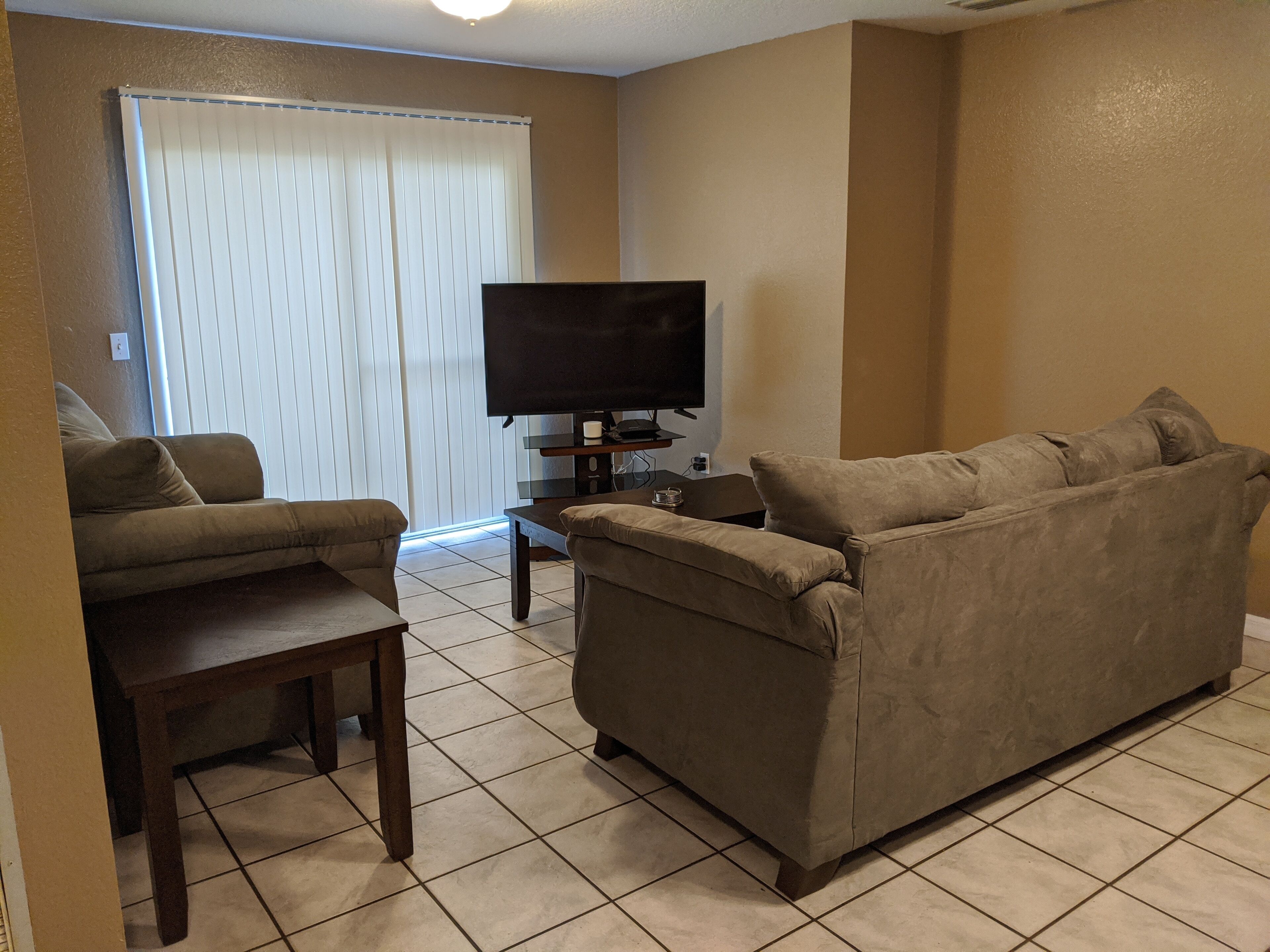 A living room with a sofa, a coffee table, and a TV.