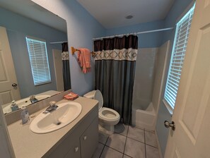 Un baño con lavamanos, inodoro y bañera.