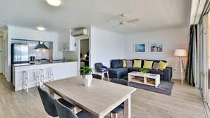 A modern living space with a dining area, kitchen, and seating area. - Whitsunday Apartment on Level 6 (Whitsundays)