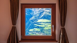 Ein Fenster mit Blick auf eine gebirgige Landschaft.