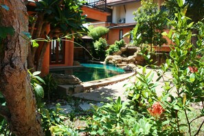 Relax by the serene pool surrounded by lush gardens and a soothing waterfall.