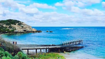 Ranta lähistöllä, aurinkotuoleja, rantapyyhkeitä