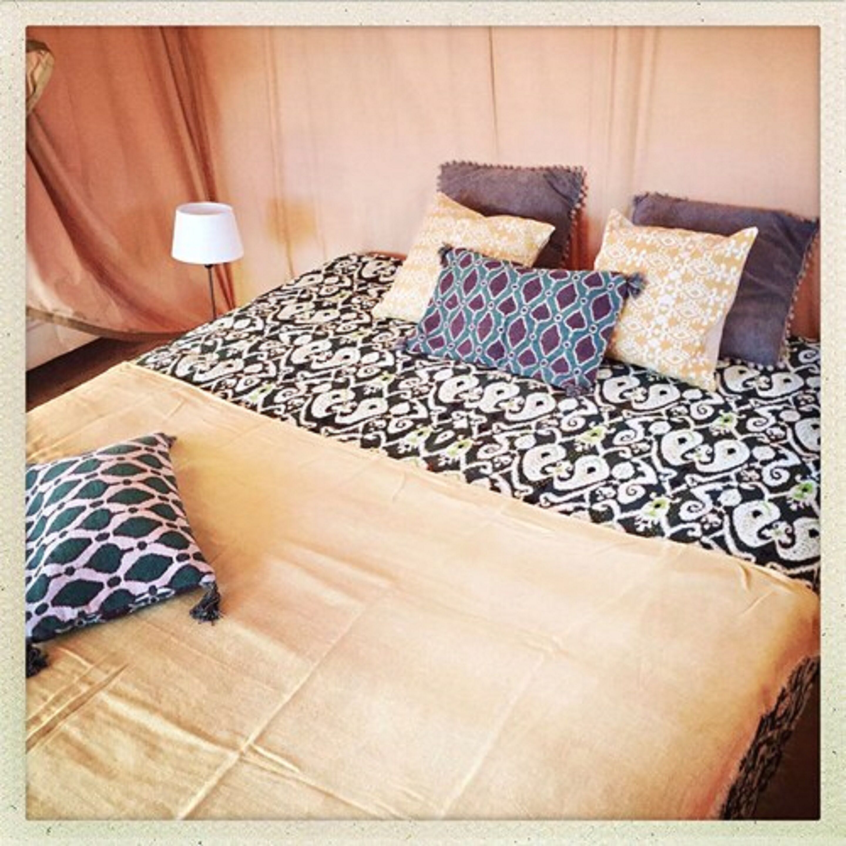 A bed with patterned bedding and multiple pillows.