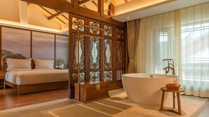 Une chambre à coucher avec un grand lit, une armoire en bois et une baignoire.