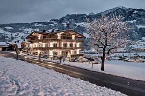 A large, multi-story wooden building with balconies, surrounded by snow-covered landscape and mountains. - Secluded Farmhouse in Tyrol near Ski Area (Schwendau)