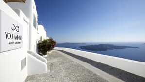 A white building with a sign reading "YOU AND ME - SUITES SANTORINI". - You And Me Suites (Santorini)
