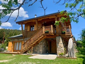 A wooden cabin with a stone foundation, wooden balconies, and a staircase leading to the upper level. - Charming Chalet Hiona (Bolquère)