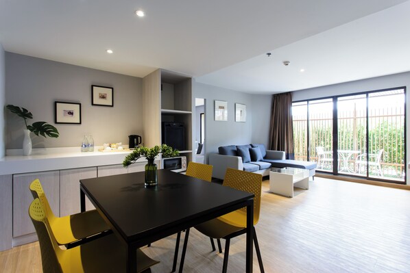 Un apartamento moderno con comedor, sala de estar con sofá y balcón con mobiliario exterior.