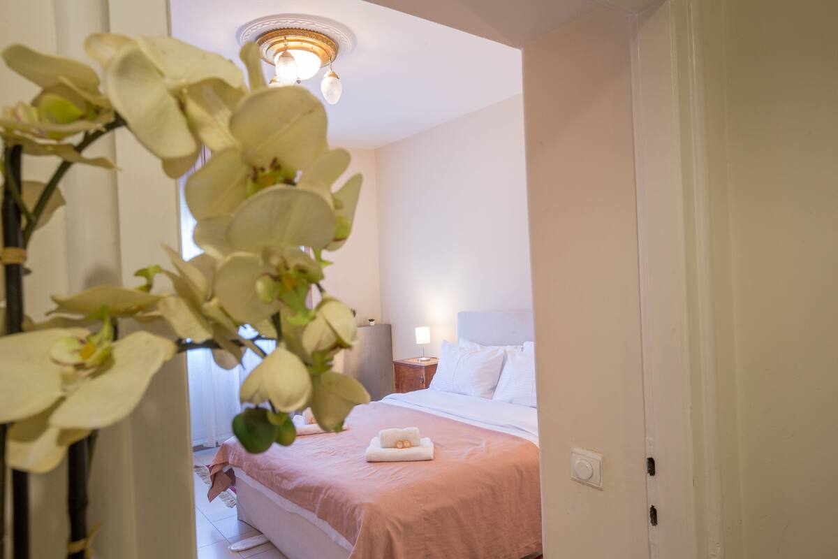 A hotel room with a bed, a nightstand, a lamp, and a ceiling light.