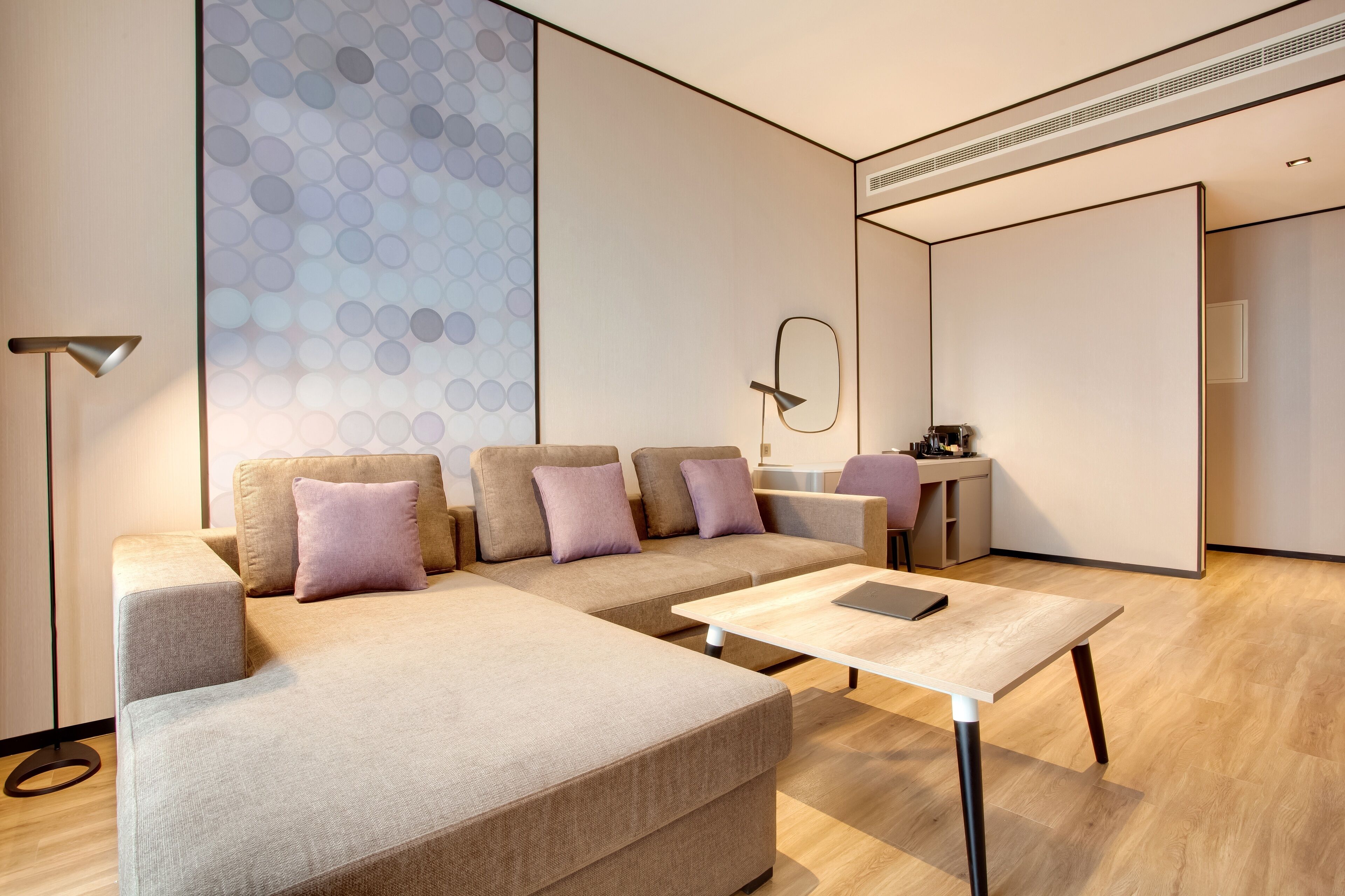 Un salon moderne avec un canapé d’angle, une table basse et un espace bureau.