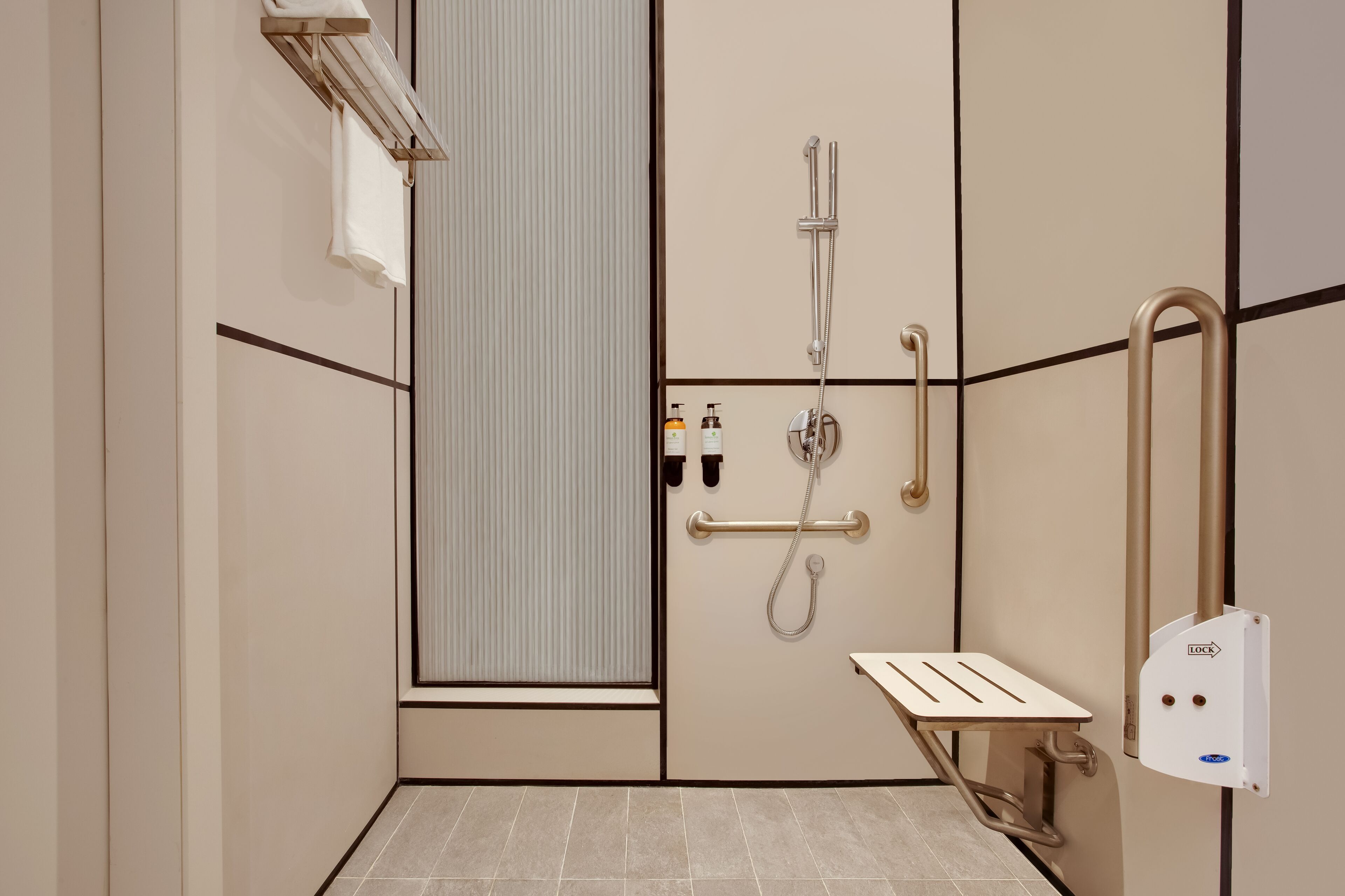 Un bagno moderno dotato di cabina doccia, maniglie di sostegno, portasci e water con barra di sicurezza.