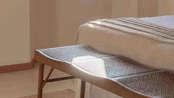 Un dormitorio con cama, una ventana con contraventanas de madera, una silla y vistas a las montañas.