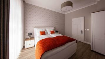 Ein Hotelzimmer mit Bett, Nachttisch, Lampe, Schrank und Tür.