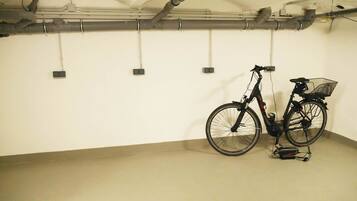 Un estacionamiento limpio y vacío, con una bicicleta apoyada en la pared.