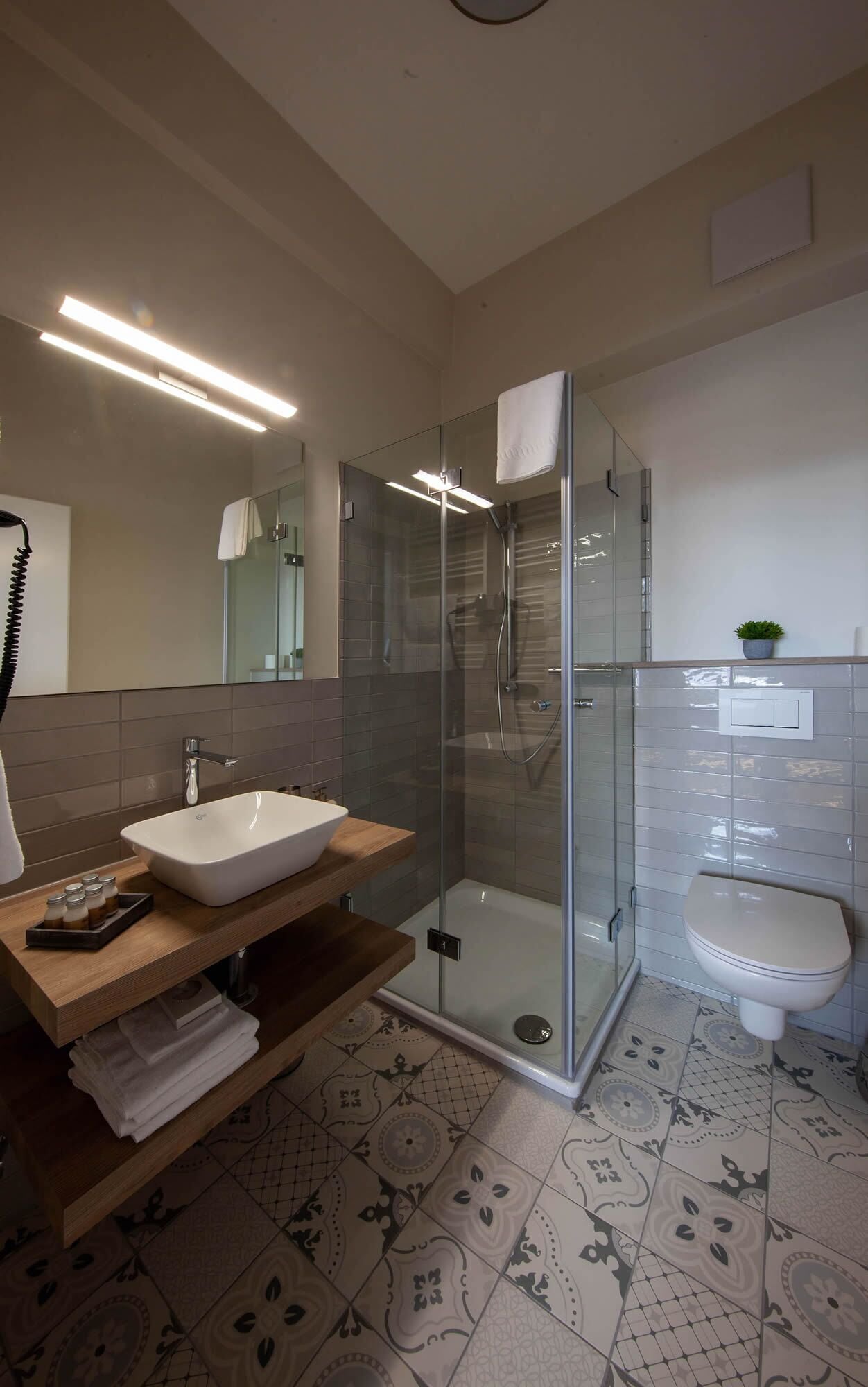 Ein modernes Badezimmer mit einer Duschkabine aus Glas, einem weißen Waschbecken und einer Toilette.