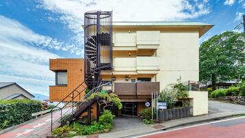 A modern hotel with a unique spiral staircase, a flat roof, and a sign indicating it is a hotel.