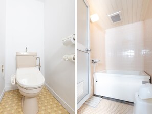 Een badkamer met toilet, douche en bad.
