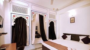 A hotel room with a bed, a desk, and curtains. - The Lake View Hotel – On Lake Pichola (Udaipur)