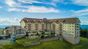 Ein mehrstöckiges Hotel mit Innenhof, Balkonen und Blick auf die umliegende Landschaft.