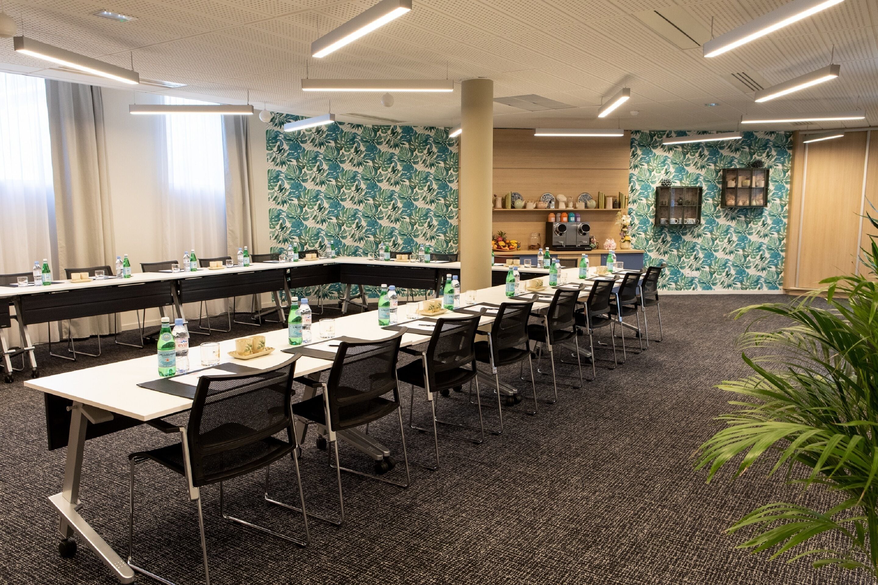 A conference room with a long table, chairs, and water bottles.