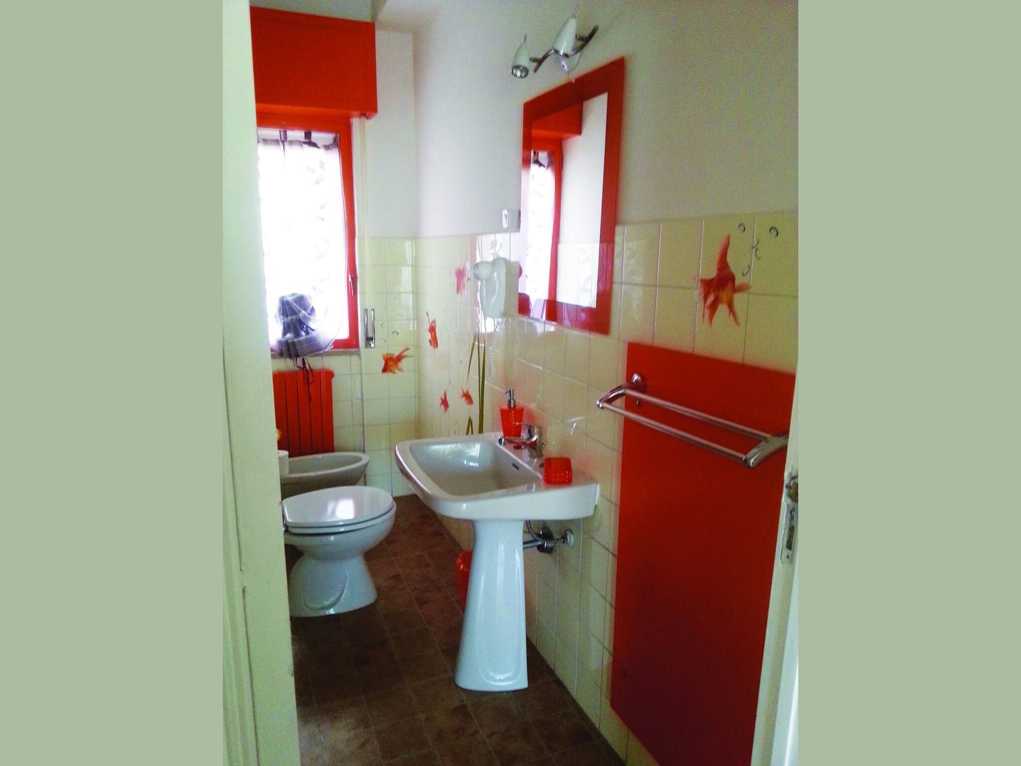 Ein Badezimmer mit zwei Toiletten, einem Waschbecken und einem Spiegel.